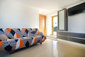salon z kanapą i telewizorem z płaskim ekranem w obiekcie Apartamento con terraza con vistas al mar w mieście Villanueva de Arosa