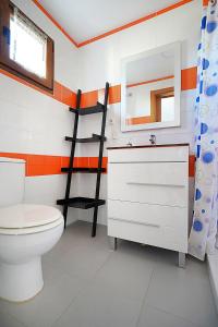 łazienka z toaletą, lustrem i półką w obiekcie Apartamento con terraza con vistas al mar w mieście Villanueva de Arosa