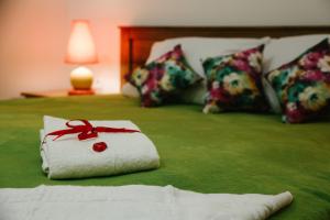 a red and white striped bed with a white blanket on top of it at Alexandria Hotel in Pryluky