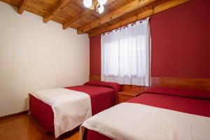 two beds in a room with red and white at Vidª Vac Honorato 2 in Santa Eulalia