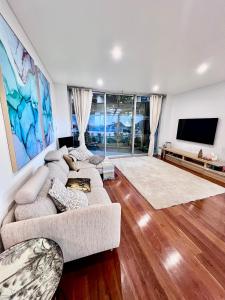 a living room with two couches and a flat screen tv at Bondi Stylish Bedroom Close to the Beach in Sydney
