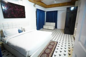 een slaapkamer met een groot wit bed en een stoel bij The Castle Villa Pine View Kasauli in Kasauli