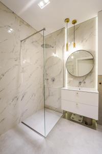 a bathroom with a shower with a mirror and a sink at Apartamenty Iława - Marina in Iława