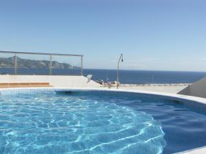 a swimming pool with the ocean in the background at Lual Plaza de España - Apartamento 1 dormitorio in Nerja
