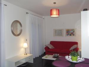 a living room with a red couch and a table at Lual Plaza de España - Apartamento 1 dormitorio in Nerja +7 photos