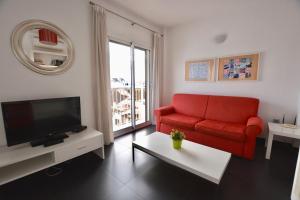 a living room with a red couch and a television at Lual Plaza de España - Apartamento 1 dormitorio in Nerja