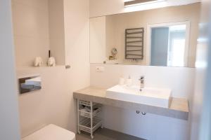 a white bathroom with a sink and a mirror at Apartamenty Iława - Marina in Iława +37 photos