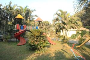 a playground with slides in a park with palm trees at Hotel Sahyadri in Achād
