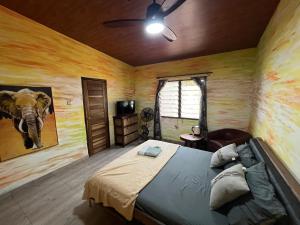 ein Schlafzimmer mit einem Bett und einem Elefantenbild in der Unterkunft Sango beach in Accra