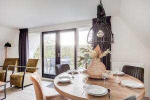 a dining room with a table with a vase on it at Rietzanger I Cottage met Mooie Inrichting in Zwiggelte