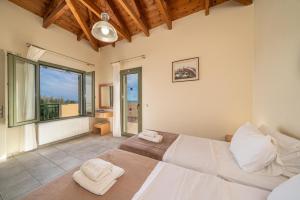 a bedroom with two beds and a large window at Villa Dinos with swimming pool in Kefallonia +30 photos