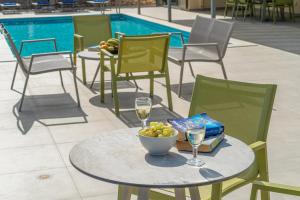 a table with a bowl of grapes and glasses of wine at Villa Dinos with swimming pool in Kefallonia