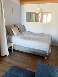 ein kleines Schlafzimmer mit einem Bett und einem Spiegel in der Unterkunft Dünenhof DB3-040 Dünenhof in Heiligenhafen