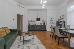 a living room with a green couch and a table at SUPREME Experience at Markovits Palace in Oradea
