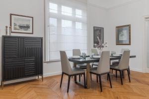 a dining room with a black table and chairs at SUPREME Experience Markovitsz-Palat Istoric-Elegant & Spațios in Oradea