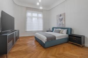 a bedroom with a bed and a flat screen tv at SUPREME Experience Markovitsz-Palat Istoric-Elegant & Spațios in Oradea