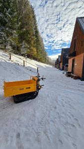 a yellow truck parked on a snow covered street at Osada Za gorami za lasami in Stronie Śląskie +62 photos
