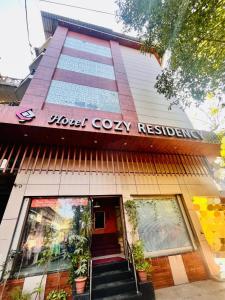 a building with a sign on the front of it at Hotel Cozy Residency in Jabalpur