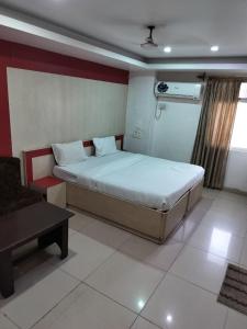 a bedroom with a bed and a couch in it at Hotel Cozy Residency in Jabalpur +4 photos