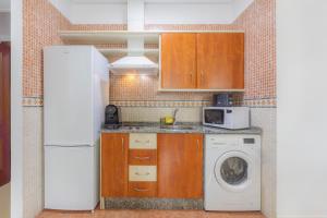 a kitchen with a washing machine and a refrigerator at Apartamentos Moon Dreams Puerto in El Puerto de Santa María +44 photos