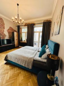 a bedroom with a bed and a chandelier at Apartamenty Narutowicza 52 parking free in Lublin