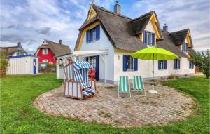 ツィローにあるCozy Home In Zierow Ot Poeler Driftの家の前の芝生の椅子2脚と傘