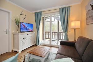 a living room with a couch and a tv at Ostseewelle Wohnung 10 in Kühlungsborn