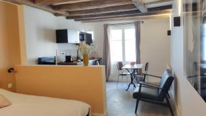 a bedroom with a bed and a table and chairs at Cœur de Chinon, tout confort ! in Chinon
