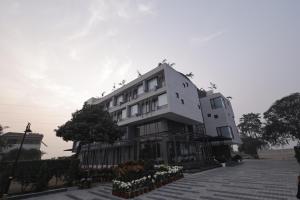 MuzaffarnagarMoolchand Resort的一座白色的建筑,上面栖息着鸟儿
