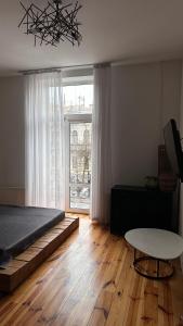 a bedroom with a bed and a table and a window at Smolynja stail in Ternopilʼ