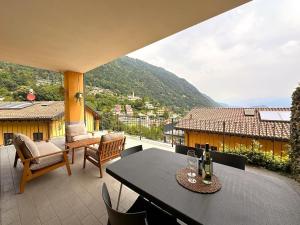 a table and chairs on a balcony with a view at Like Heaven Argegno Pool & Lake View in Argegno