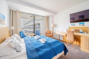 a hotel room with a bed and a desk at Horyzont Apartamenty- Seaside Apartament prywatny z widokiem na morze in Kołobrzeg