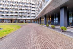 a large building with a brick walkway in front of it at Horyzont Apartamenty- Seaside Apartament prywatny z widokiem na morze in Kołobrzeg +5 photos