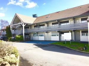 a building with a parking lot in front of it at Campanile Montesson - Le Vésinet in Montesson