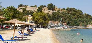 a beach with chairs and people swimming in the water at B&B one in Vonitsa