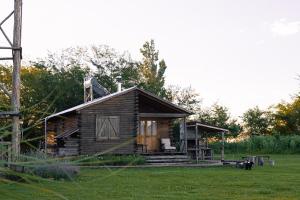 a small wooden cabin in a field of grass at Cabañas El Sosiego in Azul
