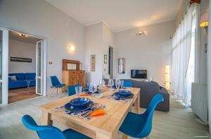 a living room with a wooden table and blue chairs at Sirene Blu Mondello in Palermo