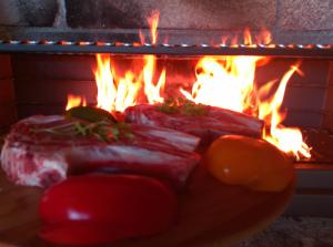two pieces of meat in front of a fireplace at Casa Quercus Galicia, a 17 minutos de Santiago! in A Estrada +46 photos