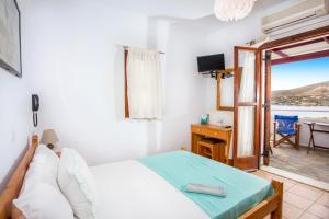 a bedroom with a bed and a desk with a view at Thalassia Studios in Kalamitsa