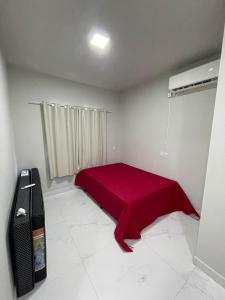 a bedroom with a red bed in a room at Seu Lar Temporário in Penha