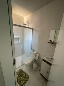 a bathroom with a toilet and a shower and a sink at Seu Lar Temporário in Penha