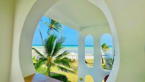 a view of the beach through an arched window at Bamburi Beach Villa in Mombasa +7 photos