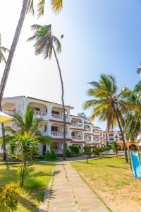 a hotel on the beach with palm trees at Bamburi Beach Villa in Mombasa
