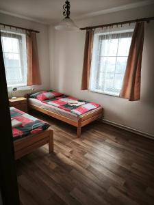 Habitación con 2 camas y 2 ventanas. en Studánecký Medvěd, en Liberec