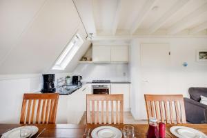 a kitchen and dining room with a table and chairs at Kuifeend I Chalet met Modern Interieur in Zwiggelte