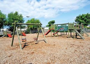 a playground with several swings in a park at Lido Beach in Prestatyn +36 photos
