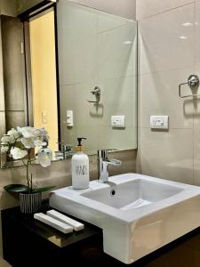ein Badezimmer mit Waschbecken und Spiegel in der Unterkunft Cozy Home at Venice Luxury BGC in Manila