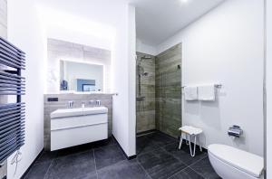 a white bathroom with a sink and a shower at Alte Seefahrtschule App 33 "Oberdeck" in Wustrow
