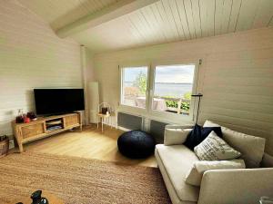 un salon avec un canapé et une télévision à écran plat dans l'établissement Coast Seven, à Borgwedel