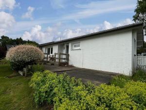 - un bâtiment blanc avec une terrasse couverte à côté d'une cour dans l'établissement Coast Seven, à Borgwedel 3 autres photos